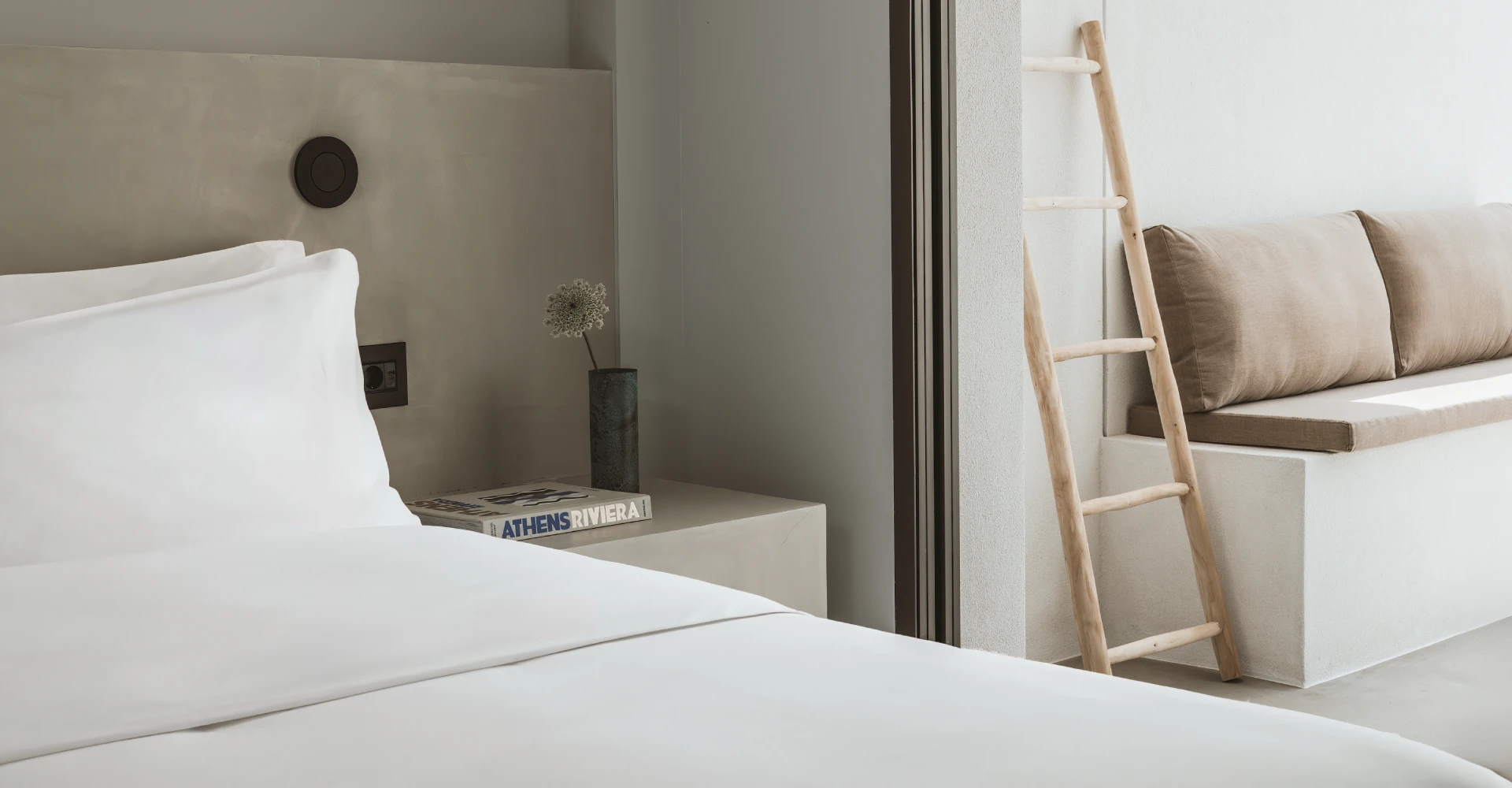 Luxury hotel room with king-size bed and sofa at Domes White Coast Milos.