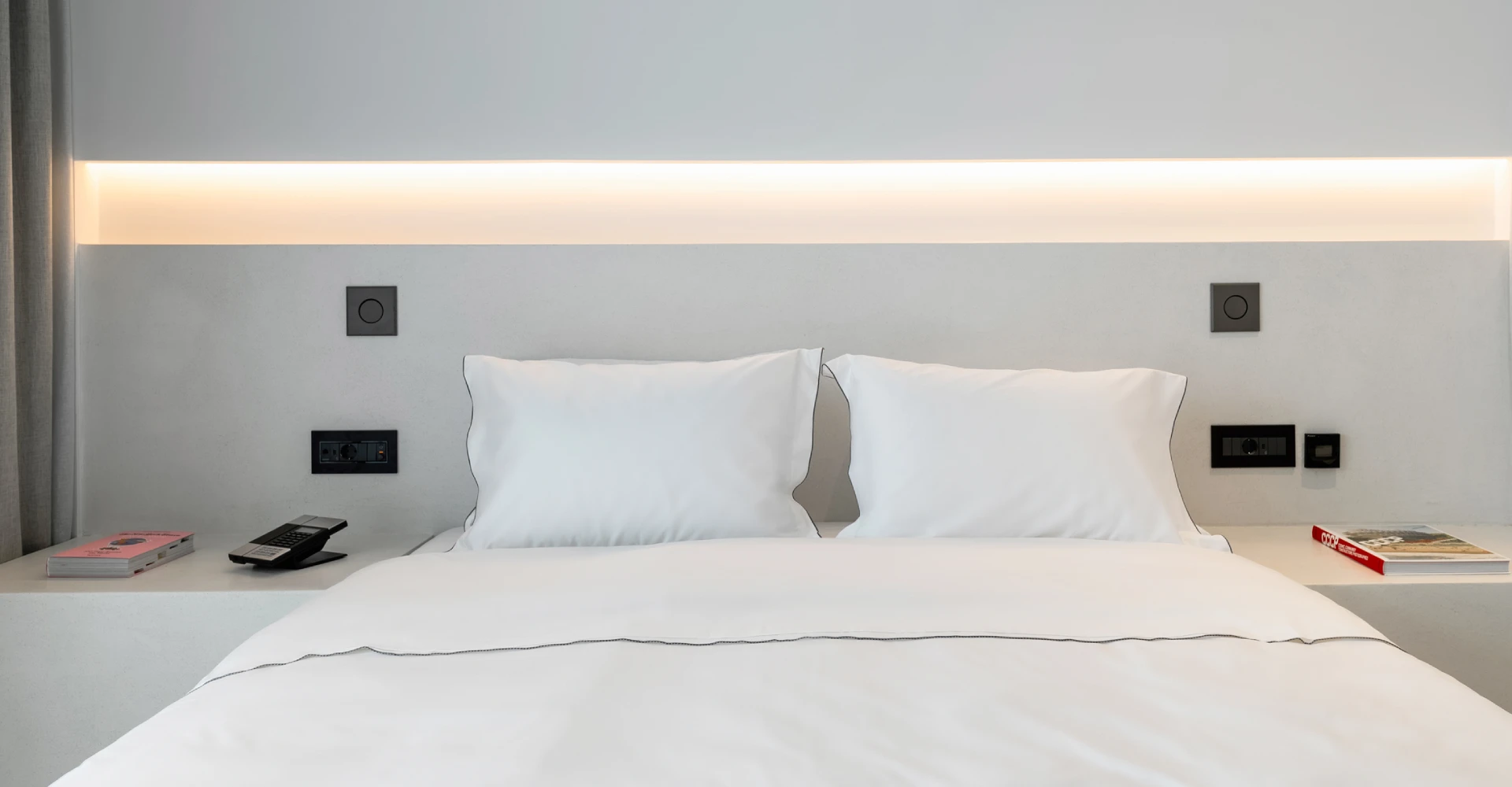 Luxury suite with comfy king size bed of exquisite linen and minimal design at Domes White Coast Milos