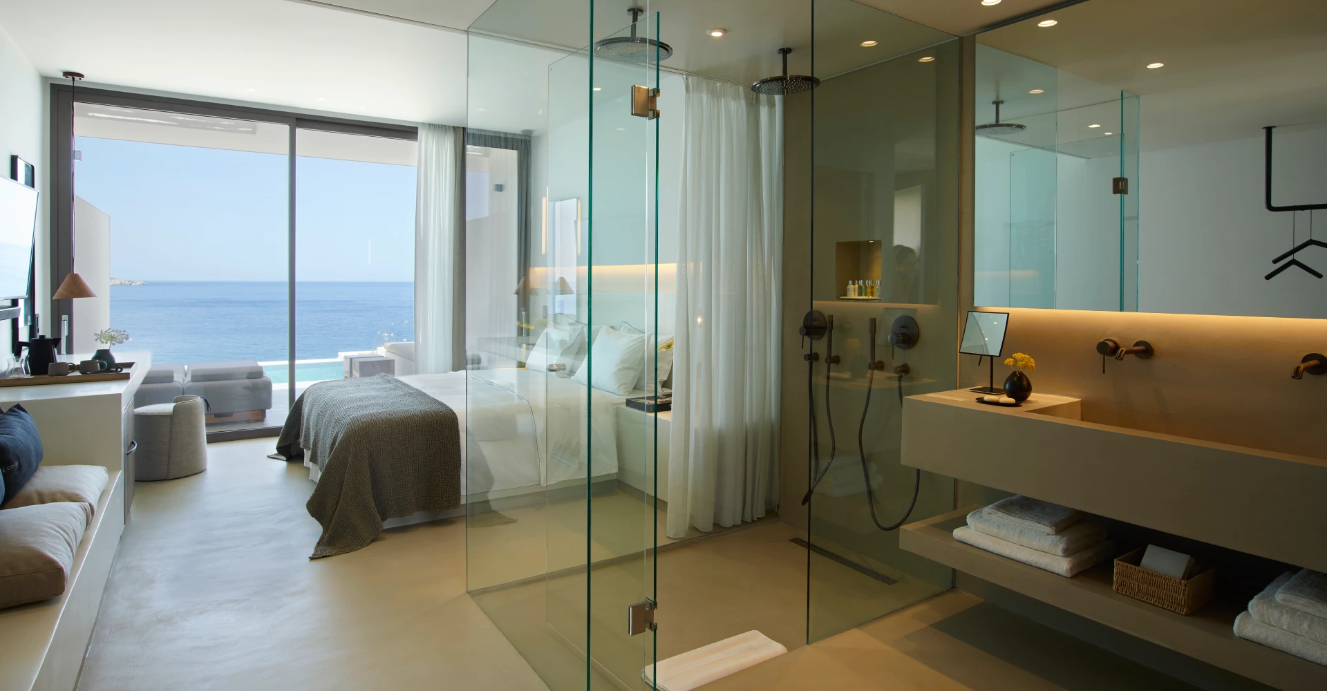 Spacious luxury deluxe suite with sea and sunset view, king size bed and double vanity bathroom at Domes White Coast Milos
