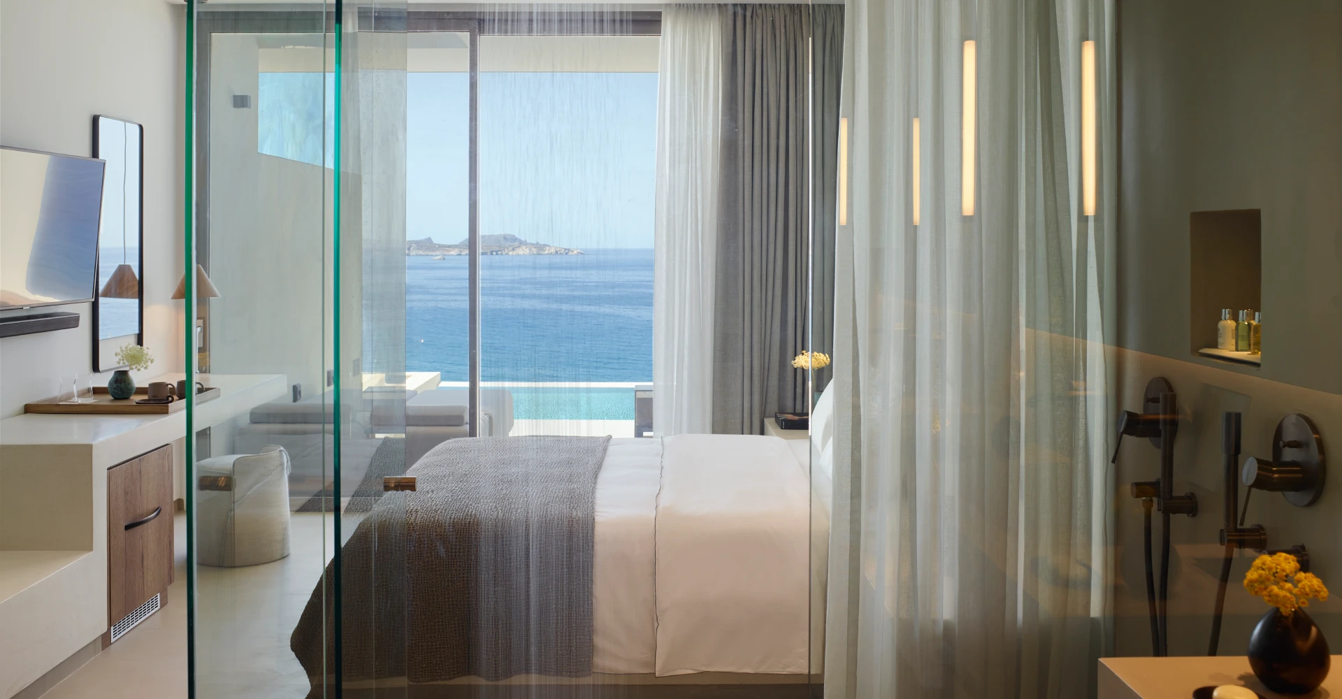 Luxury deluxe suite with breathtaking sea view and king size bed at Domes White Coast Milos