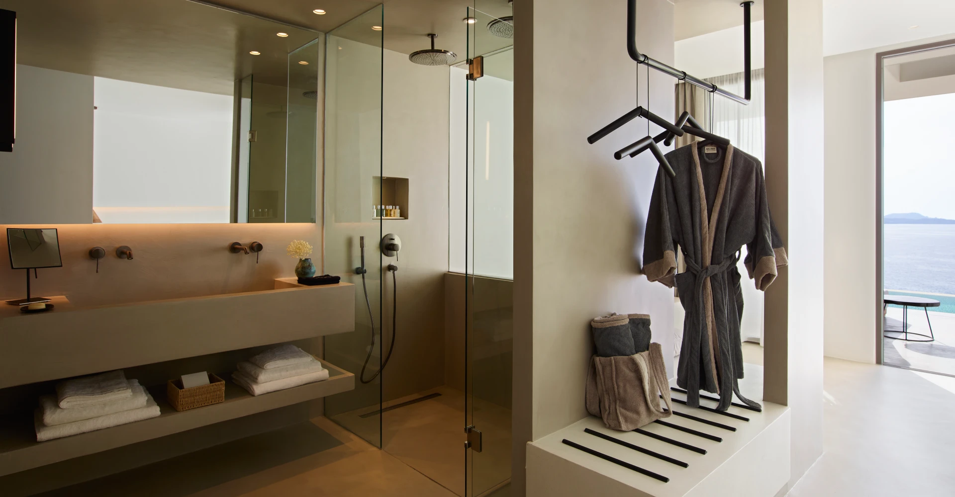 Luxurious suite with spacious concrete bathroom and dressing area overlooking the sea at Domes White Coast Milos